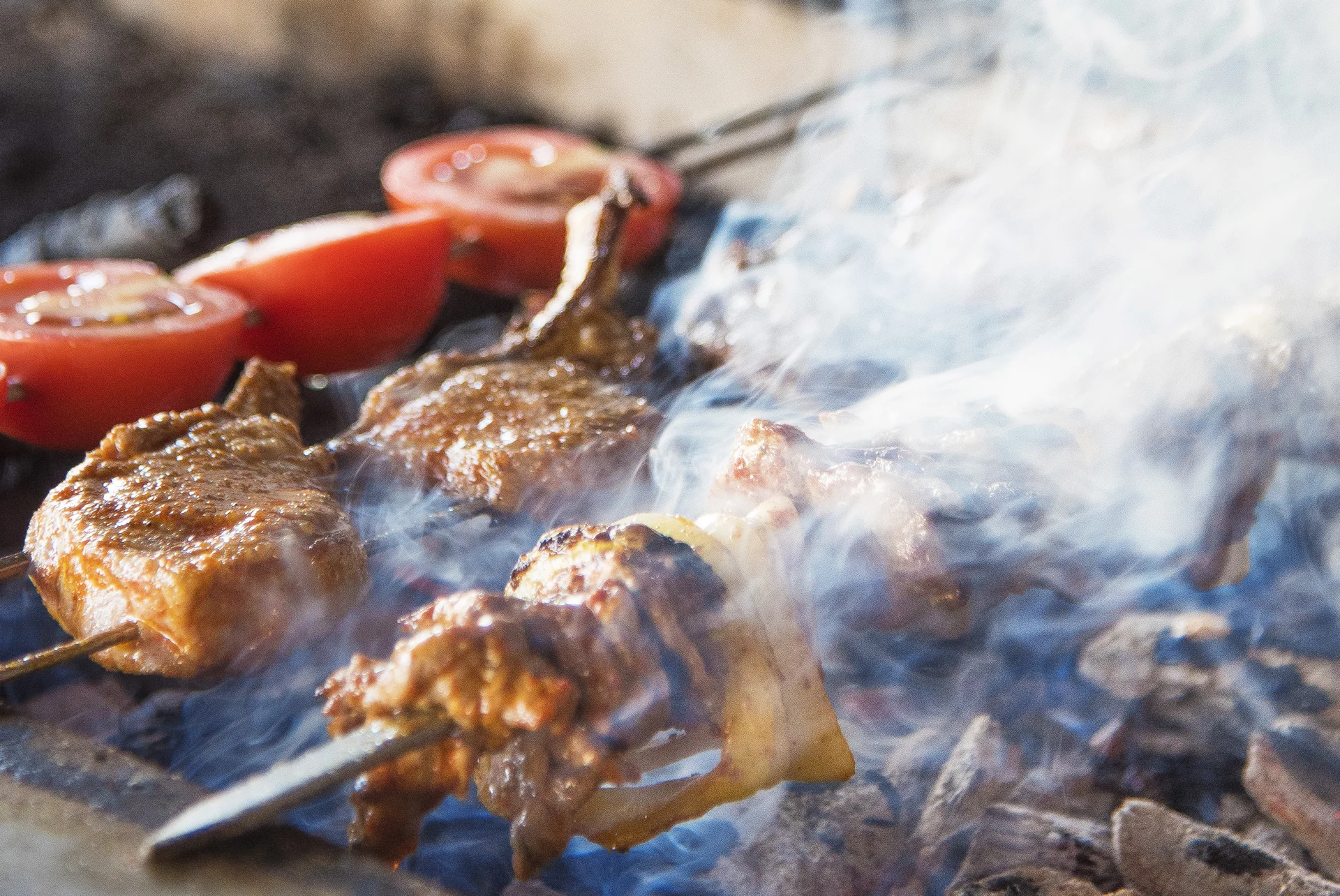 Köz ateşi üzerinde pişen kebap şişleri
